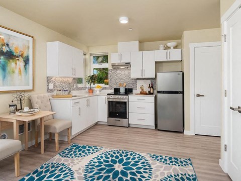 a kitchen with white cabinets and a stainless steel refrigerator