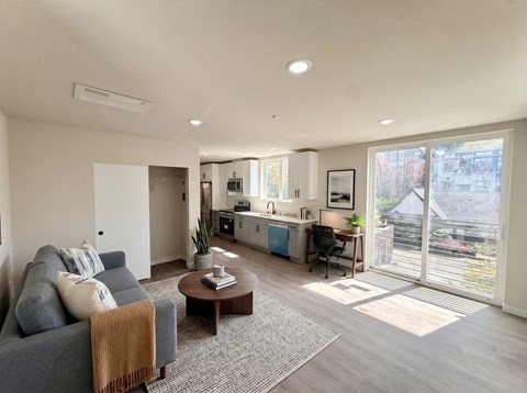 A living room with a grey couch and a brown coffee table.