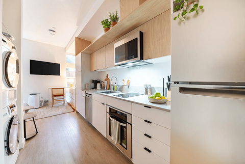 A modern kitchen with white cabinets and a wooden countertop.