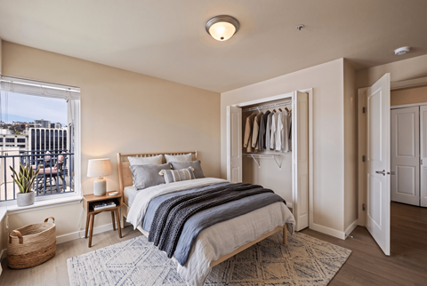 A bedroom with a large bed and a view of the city.