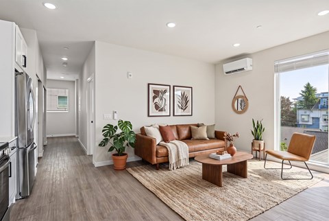 A modern living room with a brown leather couch and a wooden coffee table.