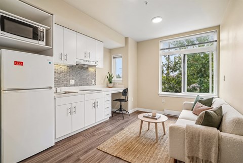 A modern kitchen with white cabinets and a refrigerator.
