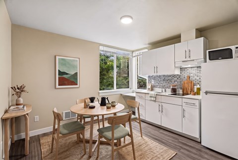 A kitchen with a table and chairs in the middle of the room.
