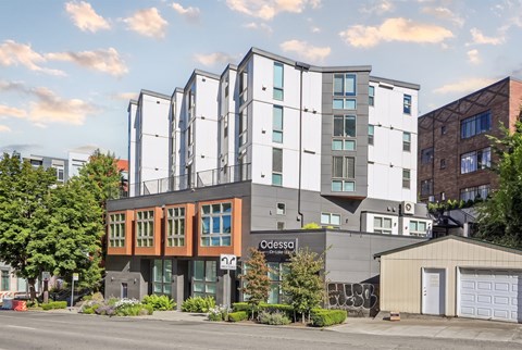 Corner view of the Odessa Apartments building at golden hour, showing the Odessa on Lake Union signage.