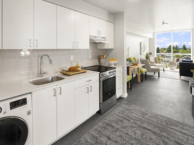 a white kitchen with a sink and a washing machine