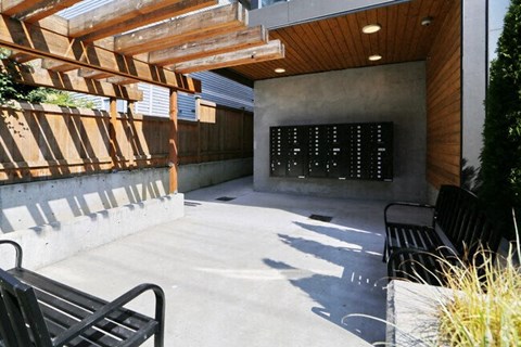 a large patio with benches and a wall in the background