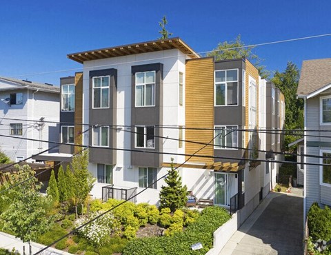 a row of apartments with balconies and a yard