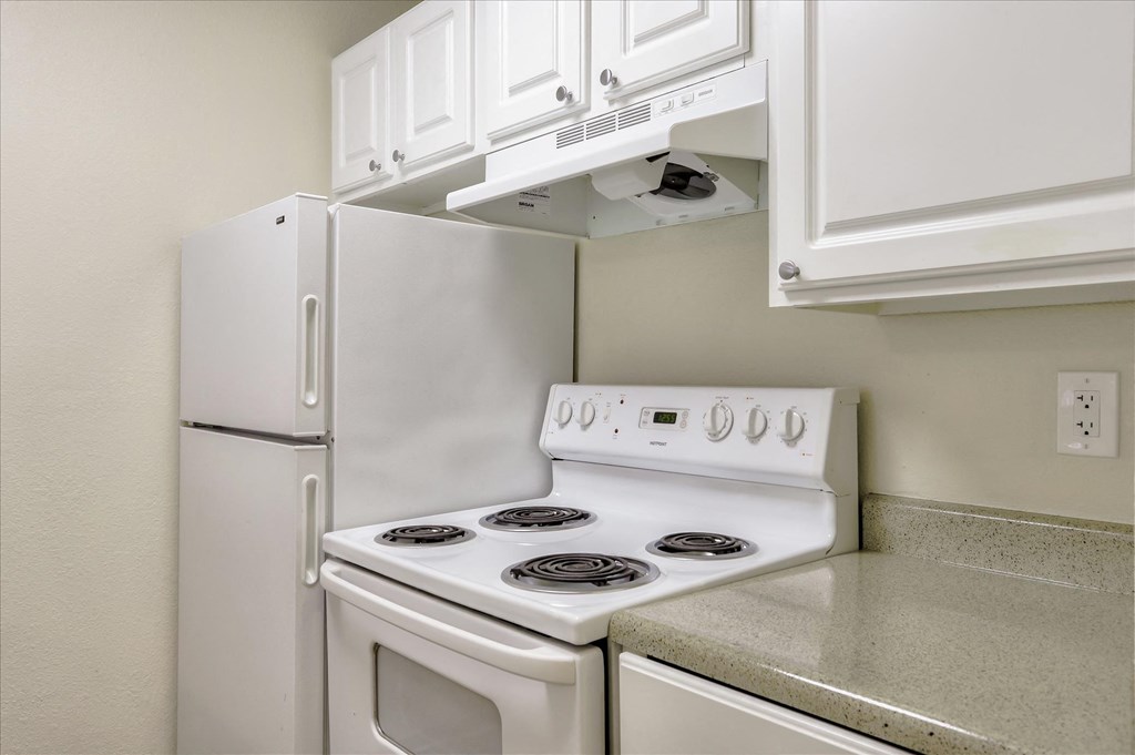 a kitchen with white appliances and white cabinets