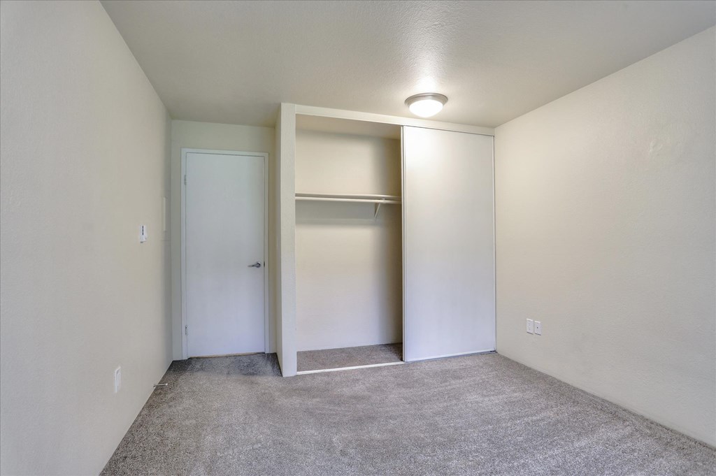 a bedroom with a closet and a door to a bathroom