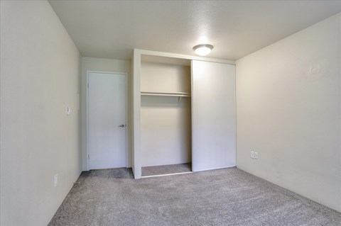 a bedroom with a closet and a door to a bathroom