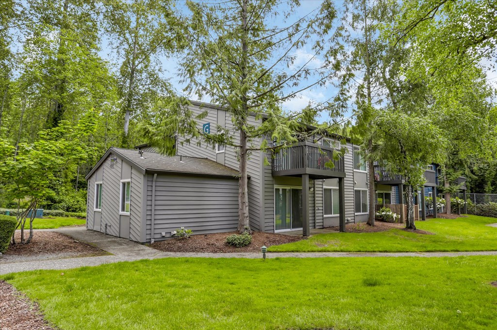 a gray house with a gray roof and a green lawn