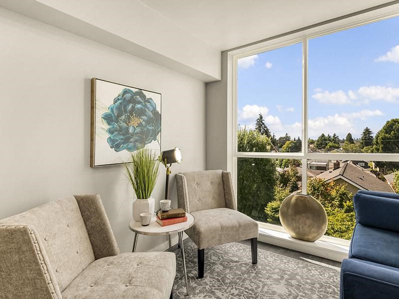 a living room with two chairs and a large window