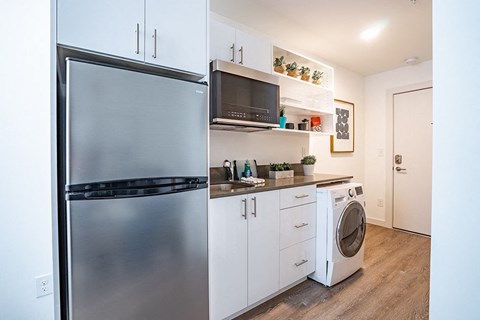 a kitchen with a refrigerator and a washing machine
