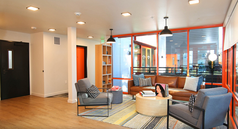 A living room with a grey chair and a brown couch.