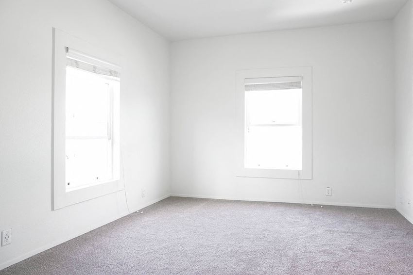 an empty room with two windows in it