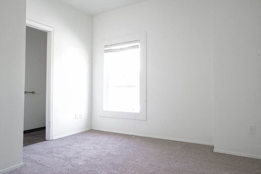 an empty room with a window and a door