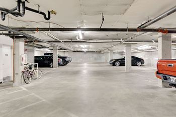 A parking garage with a white ceiling and concrete floor.