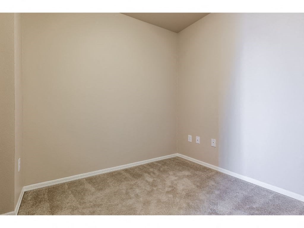 an empty room with white walls and a carpet