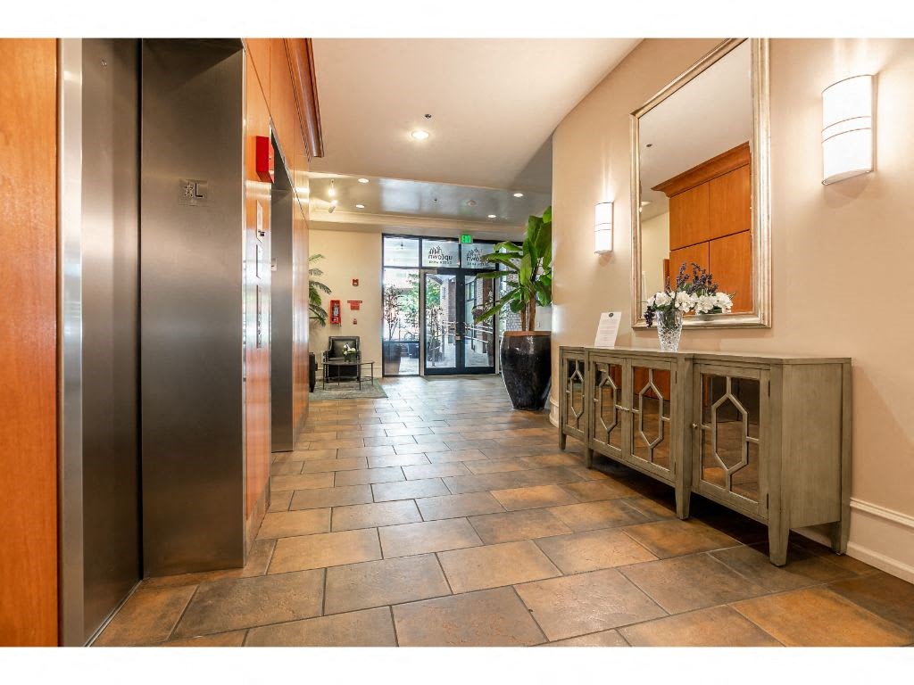 a lobby with a reception desk and a metal elevator