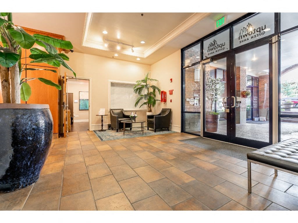a lobby with glass doors and a table and chairs