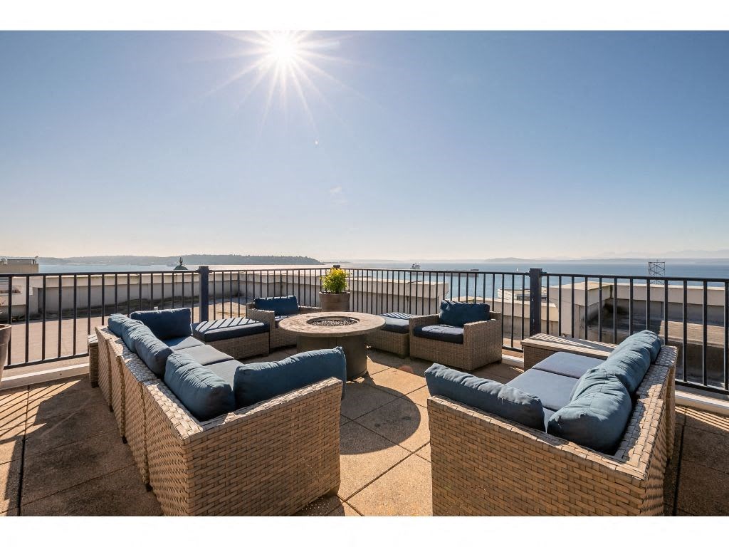 a view of the ocean from a balcony with furniture