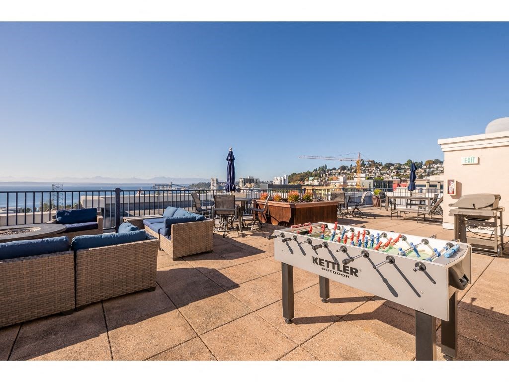 a roof terrace with a pool table and a view of the ocean