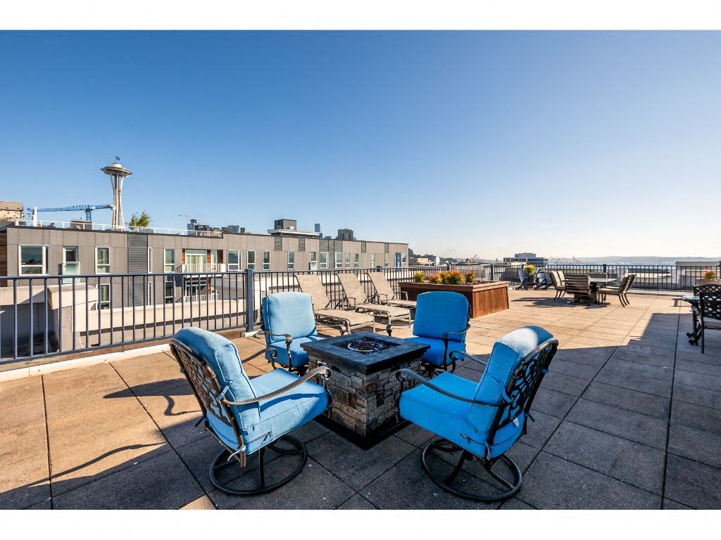 a patio with blue chairs and a fire pit