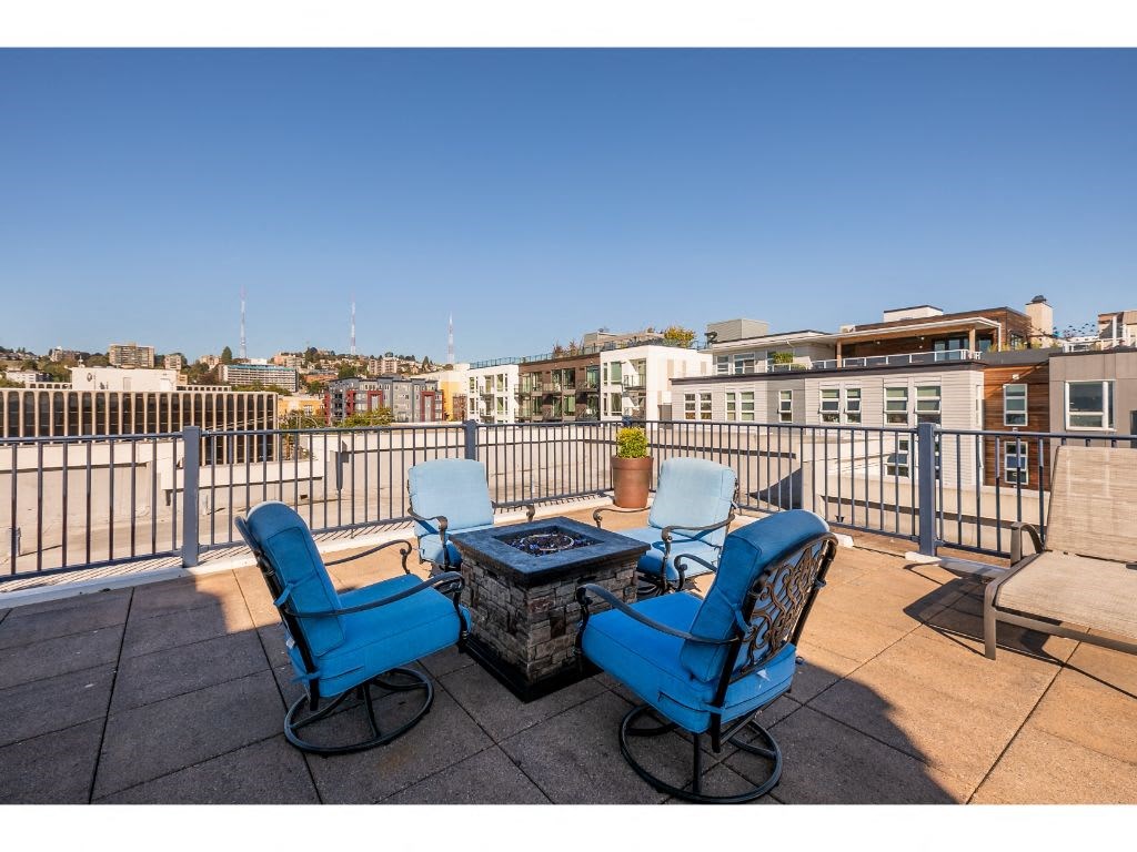 a patio with blue chairs and a fire pit
