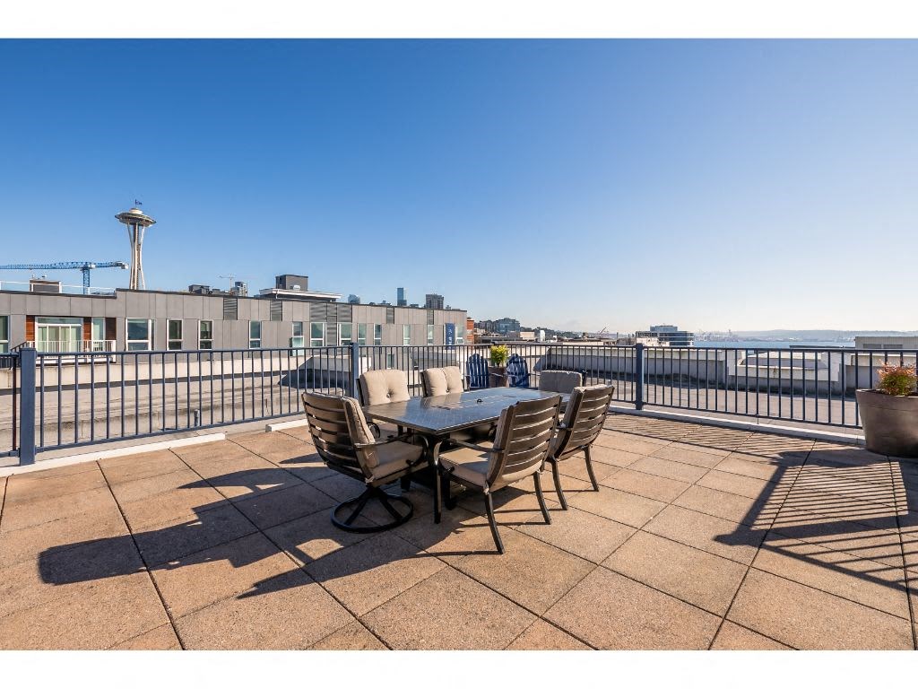 a balcony with a table and chairs and a view of the city