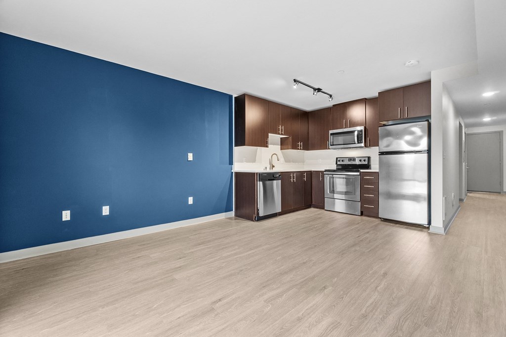 A kitchen with blue walls and wooden floors.
