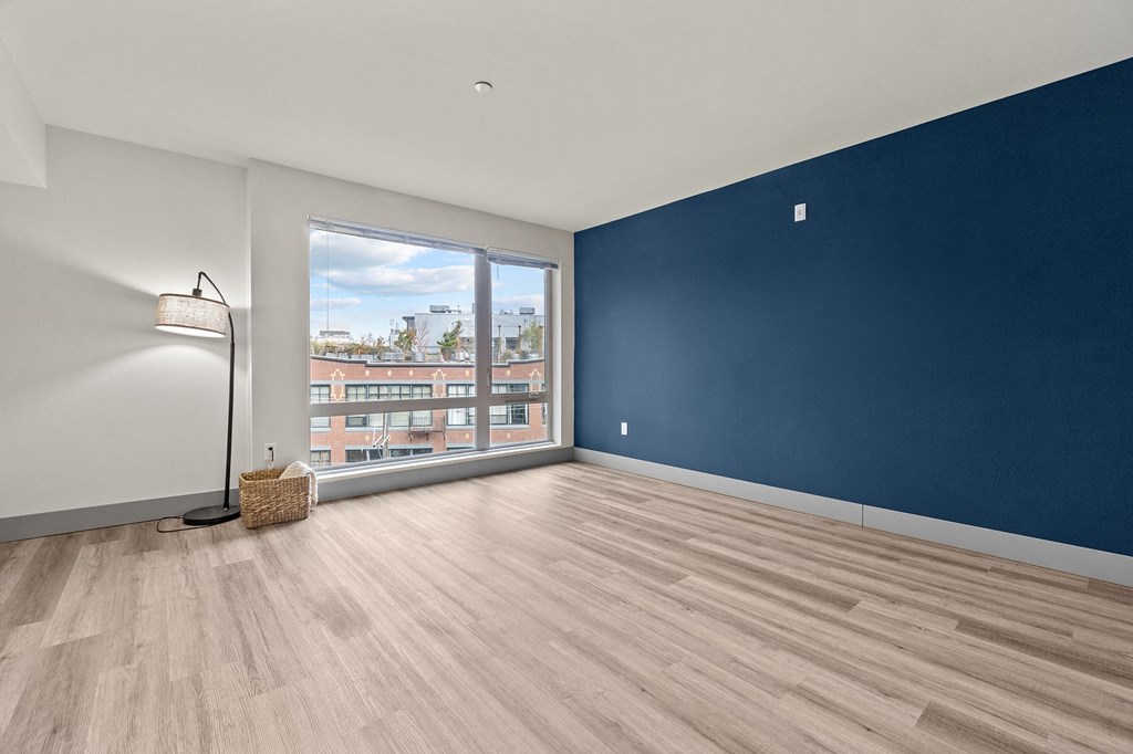 A room with a blue wall and a window overlooking a cityscape.