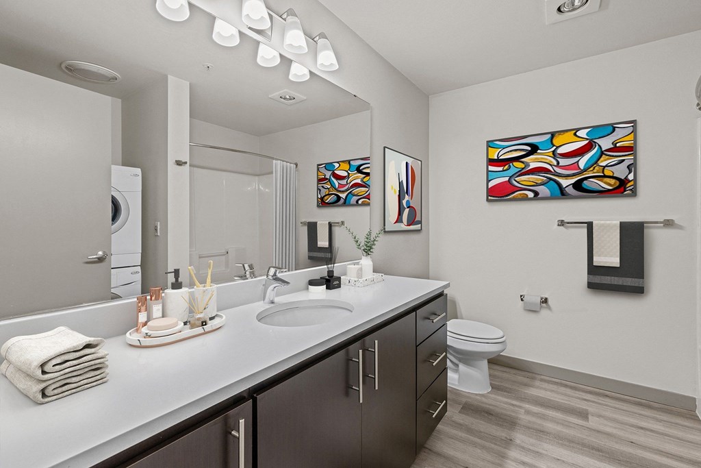 A bathroom with a white counter top and a white toilet.