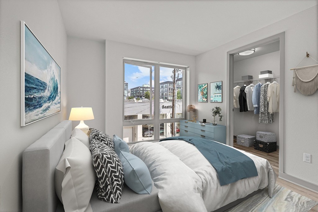 A bedroom with a large bed and a painting of a wave on the wall.