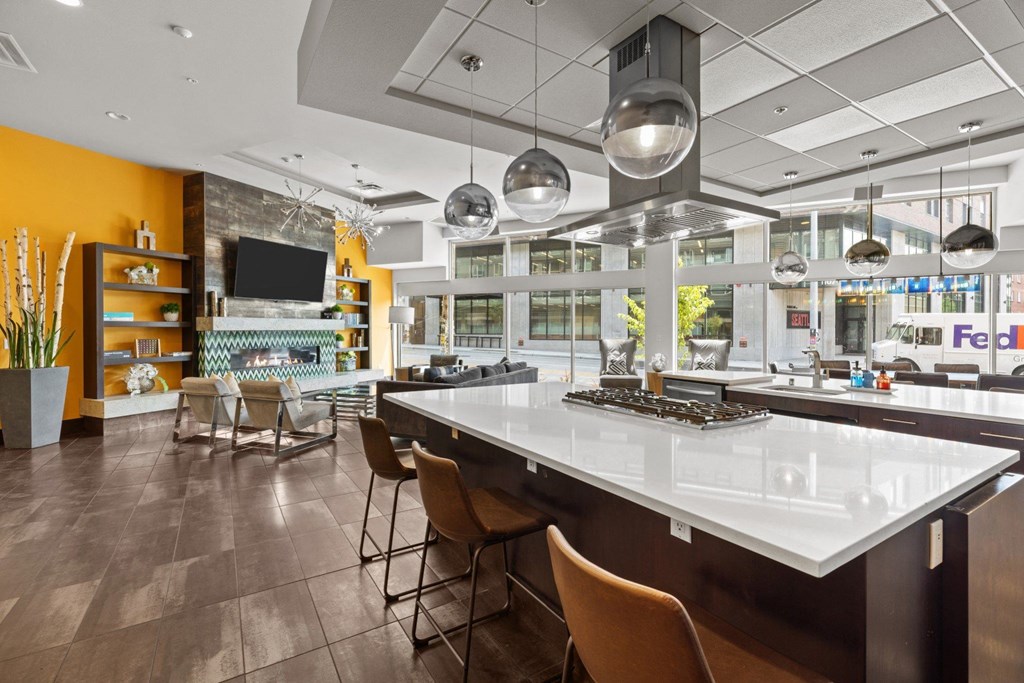 A modern kitchen with a long island and chairs.