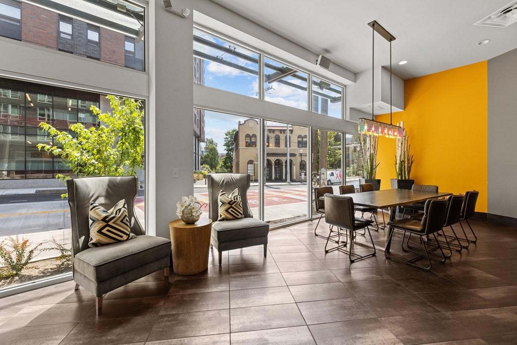 A room with a table and chairs with a view of the street outside.