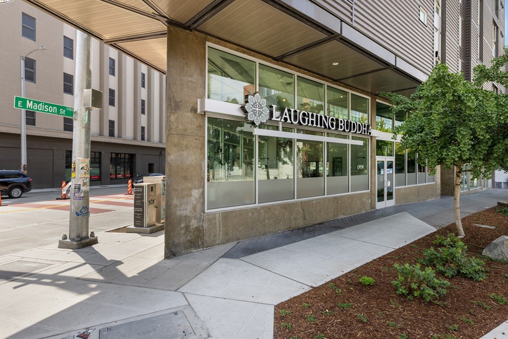 A building with a glass facade and a sign that reads "LAUGHING BUDDHA".