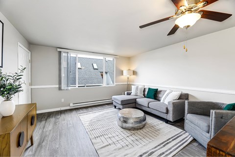 A living room with a grey couch and a wooden side table.