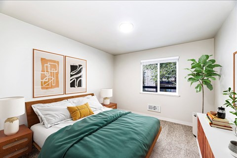 A bedroom with a bed, two lamps, a potted plant, and two framed pictures on the wall.