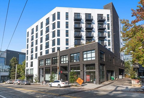 A modern multi-story building with a mix of white and dark facades.