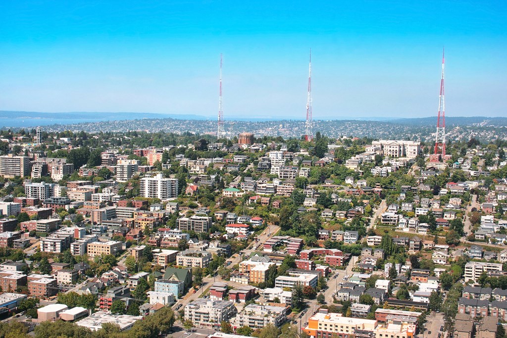A cityscape with buildings and two tall towers.