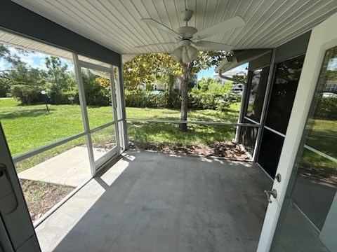 A patio with a ceiling fan and sliding glass doors.