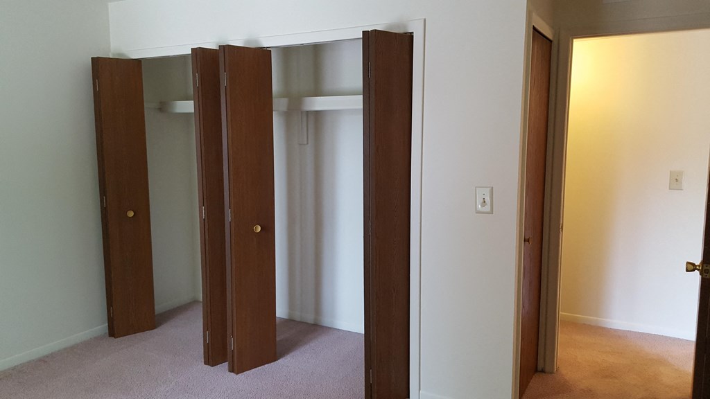 a room with three open doors and a door to a closet