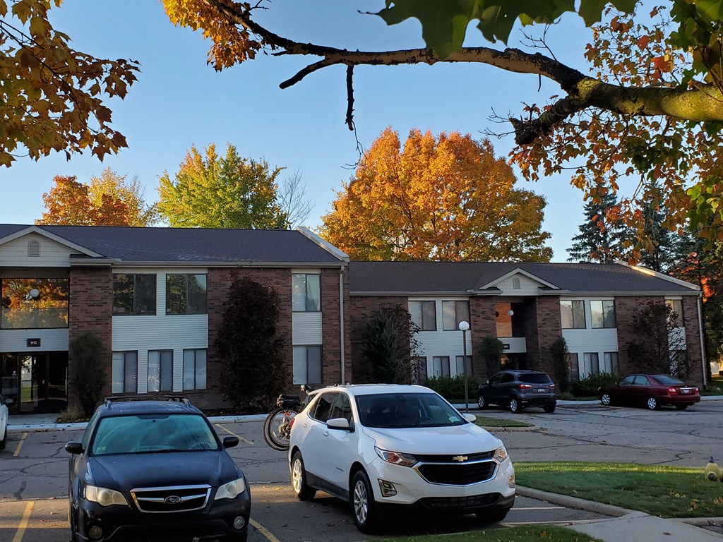 an apartment building with cars parked in front of it