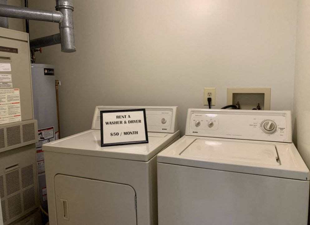 a laundry room with two washing machines and a sign on the door