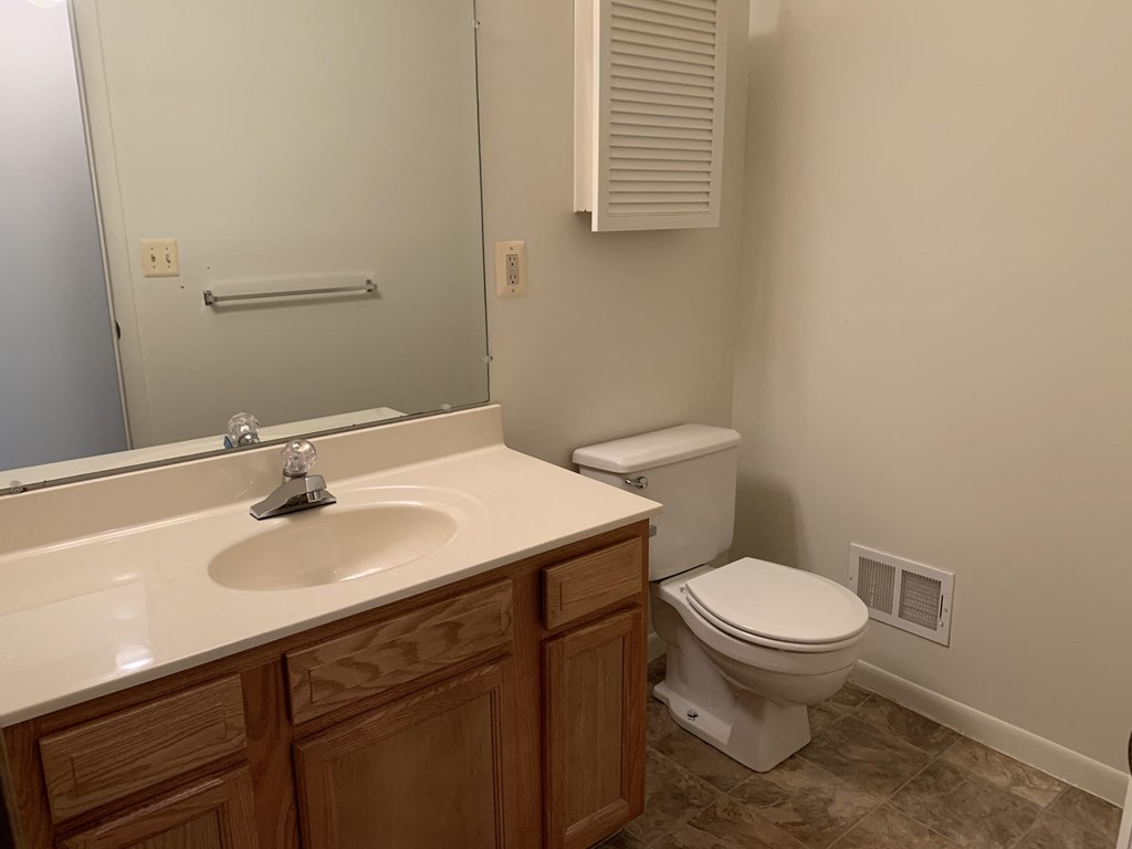 a bathroom with a sink toilet and a mirror