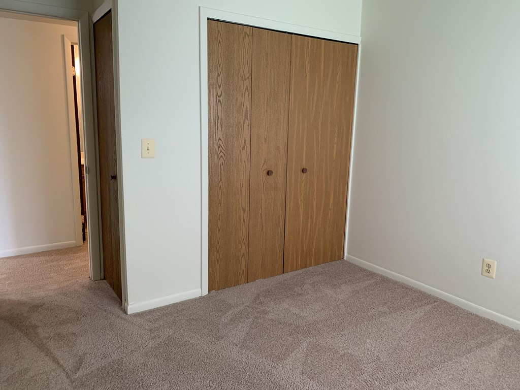 a bedroom with a closet and a door to another room