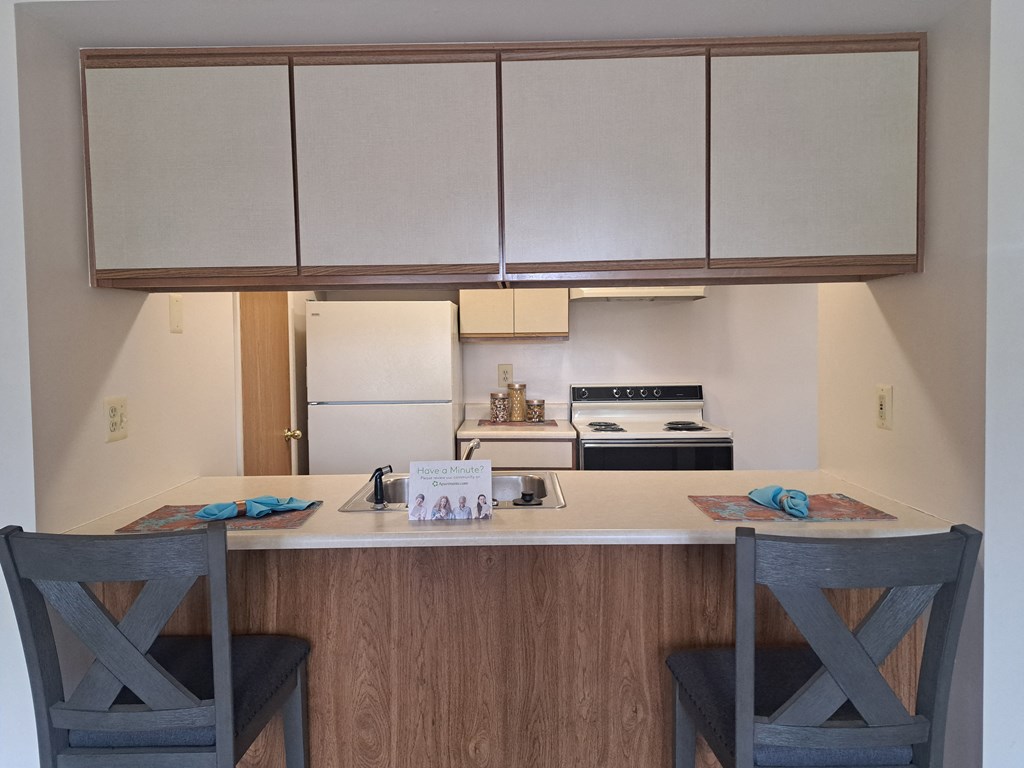 a kitchen with a counter and two chairs