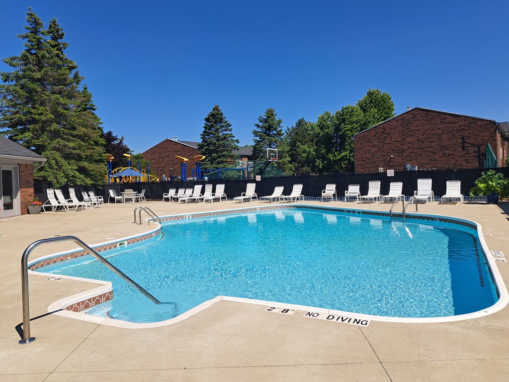 a swimming pool at a resort with chairs around it