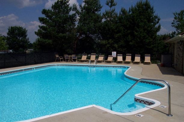 a large swimming pool with chairs around it