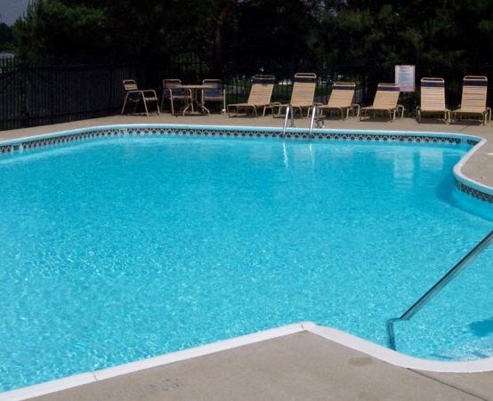 a large blue pool with chairs and chairs
